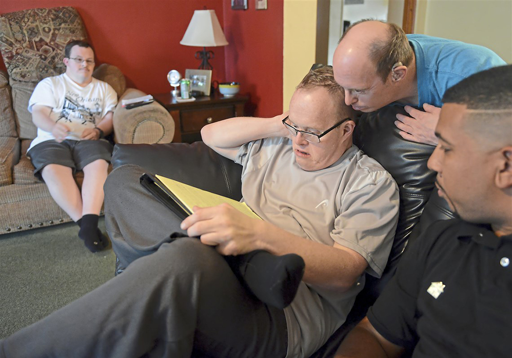 People in a group home discussing their weekly meal plan with their direct support professional.
