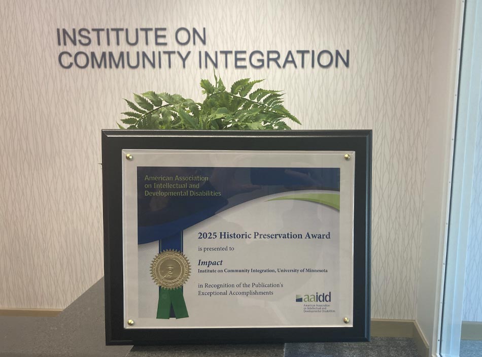 plaque sitting on a table with a plant behind it