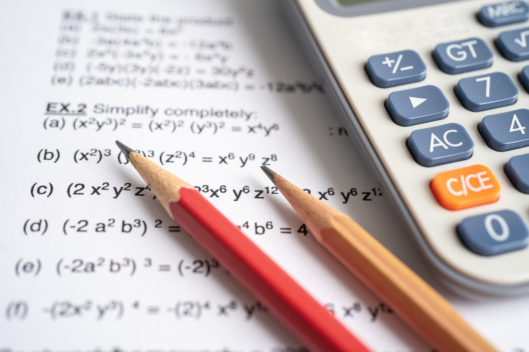 A calculator and pencils sitting on top of a math test