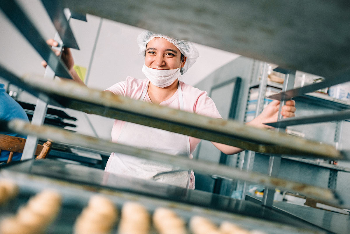 Photograph of a woman working in a bakery.